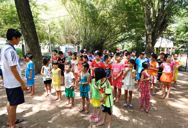 Trước khi dạy bơi, thầy giáo cho các em khởi động làm nóng người... (ảnh: Phú Quý)