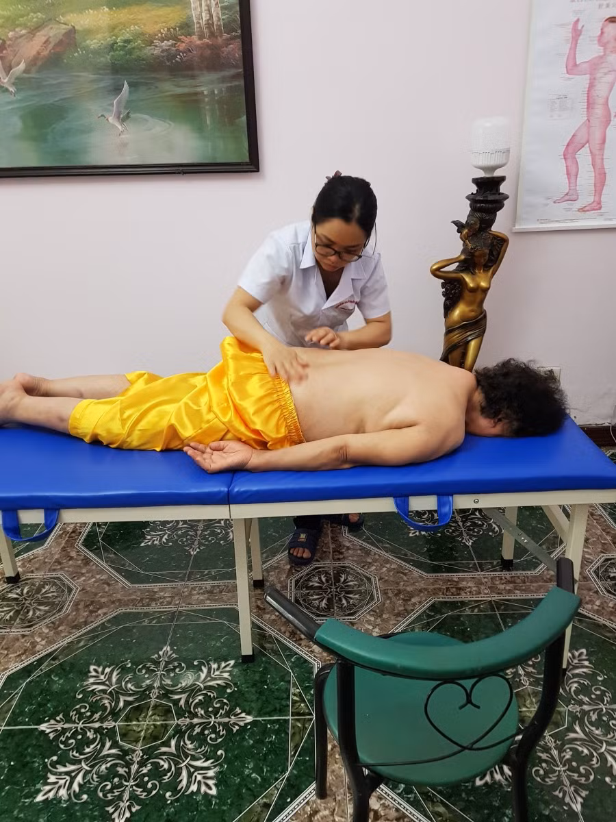 Nhân viên của chi nhánh đang xoa bóp bấm huyệt cho bệnh nhân.