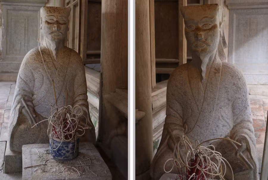 Hai vị quan văn ngồi hai bên trước cửa chính của hậu cung với thần thái sống động.