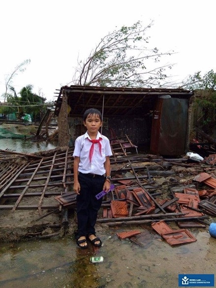 Một học sinh trước ngôi nhà tan hoang của mình sau cơn bão số 12