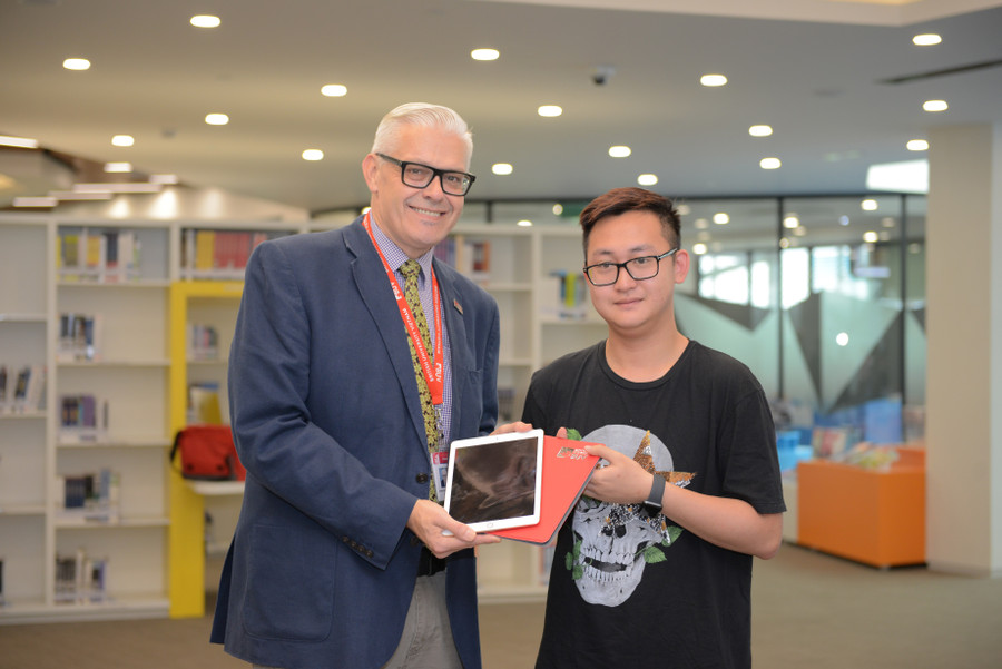 Thầy Chris trao iPad cho một bạn sinh viên khi nhập học.