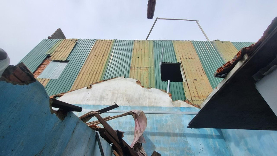 Bức tường tầng trên của căn nhà hàng xóm đã đập thẳng xuống mái nhà ông Hà. Bức tường tầng trên của căn nhà hàng xóm đã đập thẳng xuống mái nhà ông Hà.