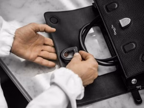 Cận cảnh quy trình kỳ công tạo ra chiếc túi Dior khiến hàng triệu quý cô điên đảo ảnh 6 Người thợ cẩn thận gắn chiếc khóa vào phía trong nắp túi. Chiếc túi có thiết kế nắp mở ra phía sau, có khóa đóng và móc khóa bên hông.