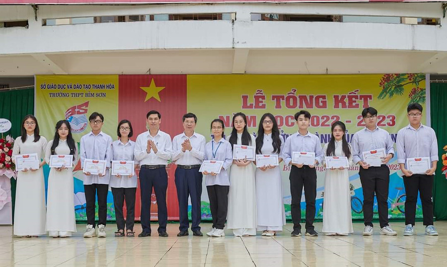 Ông Trịnh Quốc Đạt - Phó chủ tịch thị xã Bỉm Sơn (thứ 5 từ trái qua) và thầy Nguyễn Văn Hải - Hiệu trưởng nhà trường (thứ 6 từ trái qua) trao thưởng cho 11 lớp có thành tích xuất sắc trong nhất năm học 2022-2023. (Ảnh: LT).