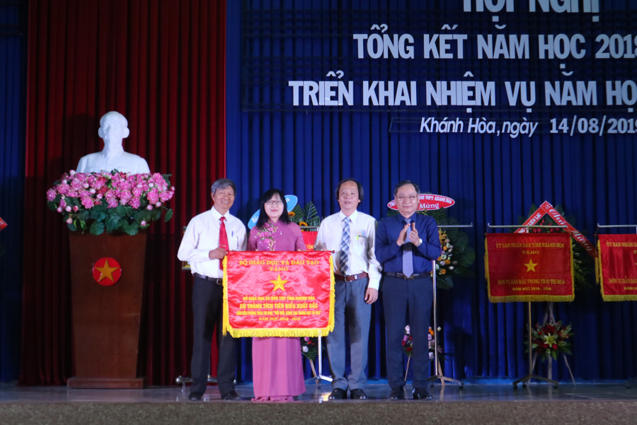 Bà Hoàng Thị Lý, PGĐ Phụ trách Sở GD&ĐT Khánh Hòa, nhận cờ thi đua của Bộ GD&ĐT