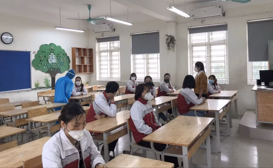 Học sinh ngồi trong lớp theo giãn cách.