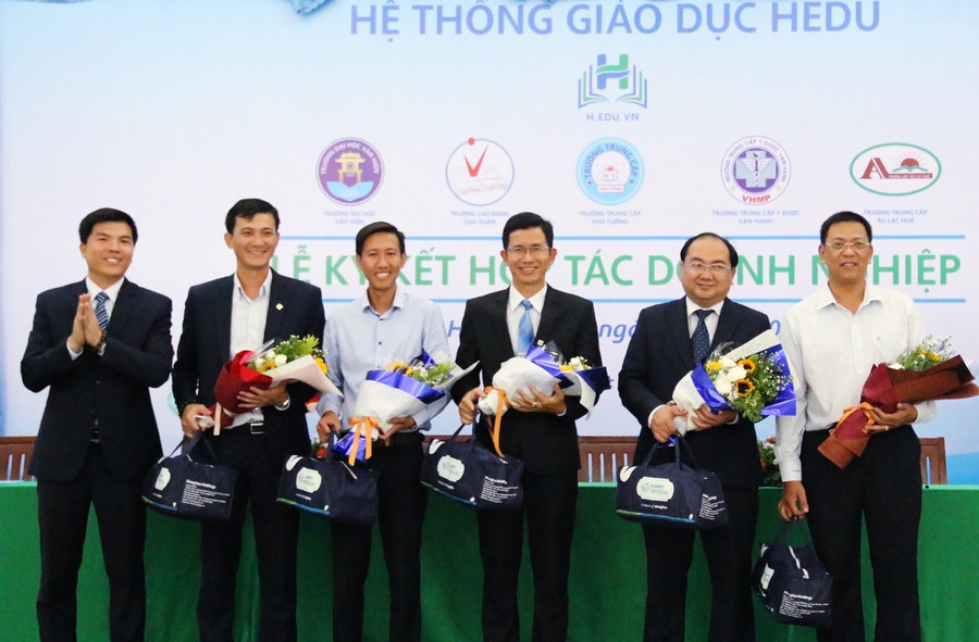 Ông Vũ Quang Chính - Tổng Giám đốc Cty CP Giáo dục Hùng Hậu lên tặng hoa và quà cho các doanh nghiệp