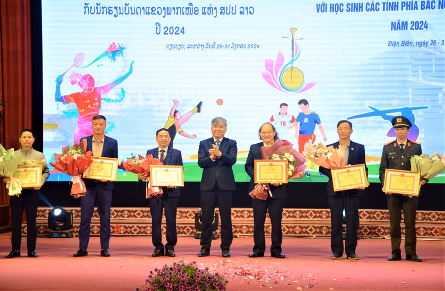 Ông Lò Văn Tiến, Phó Chủ tịch UBND tỉnh Điện Biên (đứng giữa) trao bằng khen cho các cá nhân, tập thể có thành tích xuất sắc trong tổ chức chương trình.