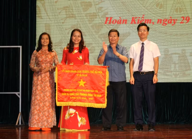 Đồng chí Vương Hương Giang, Trưởng phòng GD&ĐT quận Hoàn Kiếm, thay mặt Ngành GD&ĐT quận Hoàn Kiếm đón nhận Cờ “Đơn vị xuất sắc phong trào thi đua” của UBND Thành phố Hà Nội