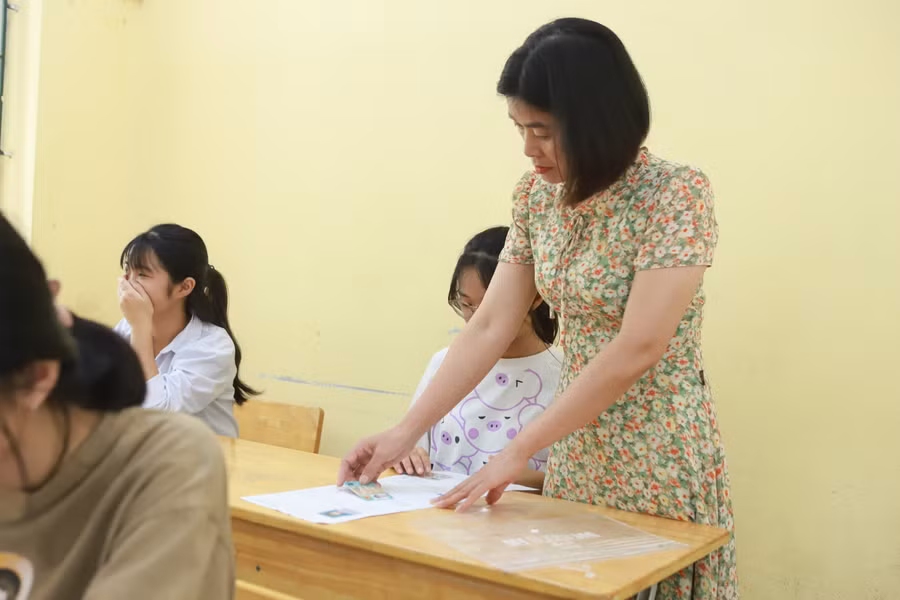 Cán bộ giám thị kiểm tra, đối chiếu thông tin của thí sinh ghi trên thẻ dự thi.