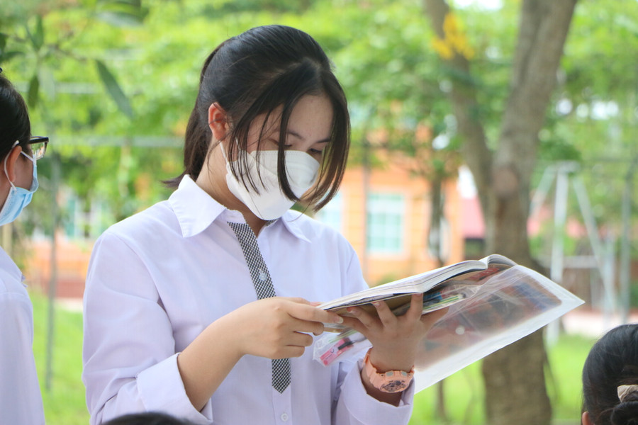 Nhiều thí sinh tranh thủ đọc lại bài trước khi đến giờ được giám thị gọi vào phòng thi.