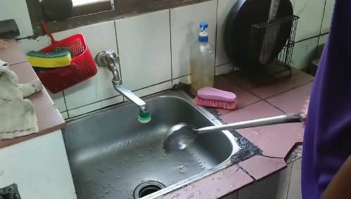 Anh He đi ủng và dùng muỗng có cán để bật/ tắt vòi nước. Ảnh:Ebc. Đi ủng và dùng muỗng có cán để bật/ tắt vòi nước. Ảnh: Ebc.