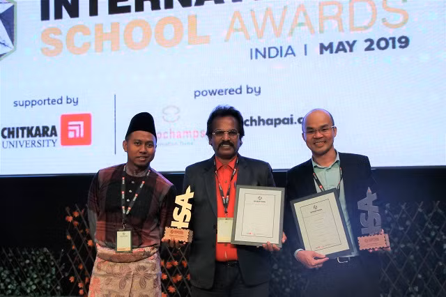 Ông Ngô Thành Nam (bìa phải)- Phó phòng tiểu học Ban chuyên môn K-12 đại diện Tập đoàn nhận giải thưởng ISA 2019