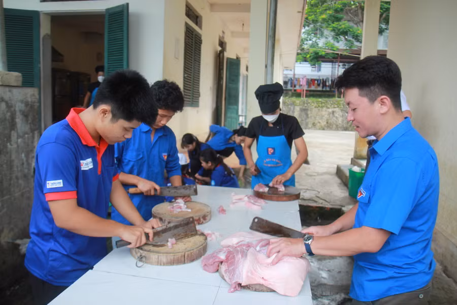 Anh Pờ Vũ Thanh Bình, Phó Bí thư Huyện đoàn Mường Tè (bên phải) trực tiếp hỗ trợ nấu ăn tại trường PTDTNT huyện Mường Tè.
