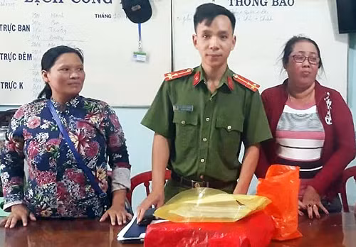 Chị Mai (trái) bàn giao tài sản nhặt được ở trụ sở công an. Ảnh: Công an cung cấp.