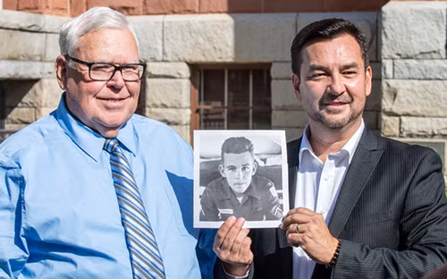 Hugh Nguyen đứng cạnh cha ruột Roy Patterson và cầm bức ảnh của ông khi còn là một binh lính Mỹ 18 tuổi. Ảnh: OC Register