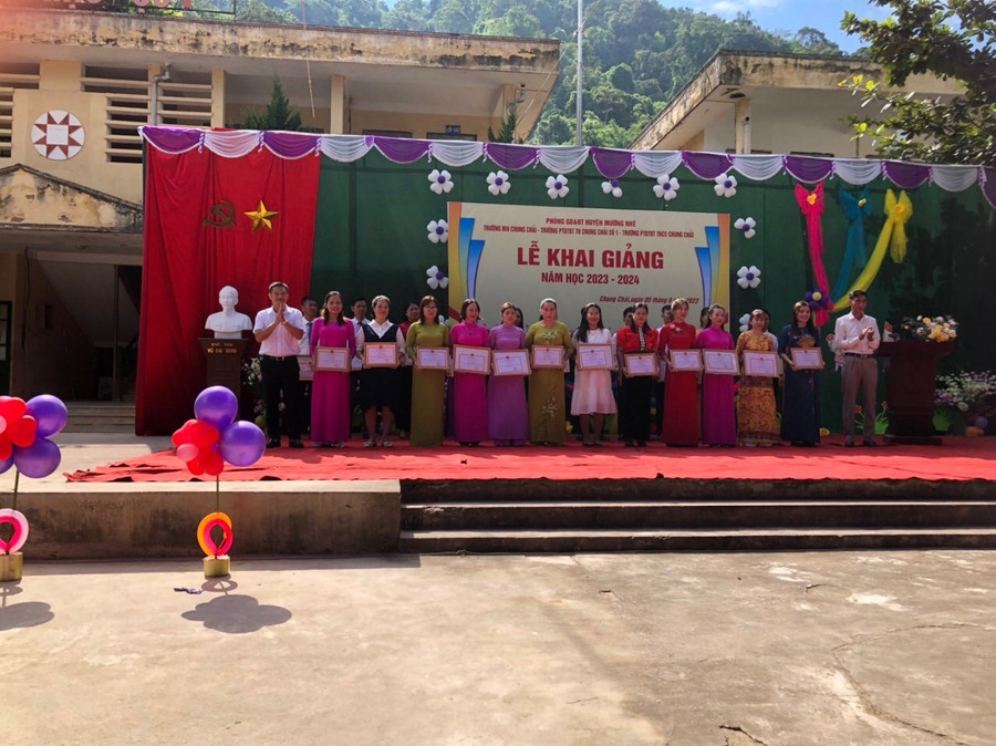 Ông Nguyễn Văn Hưng (ngoài cùng bên trái) trao thưởng các cá nhân có thành tích xuất sắc trong năm học 2022 - 2023.