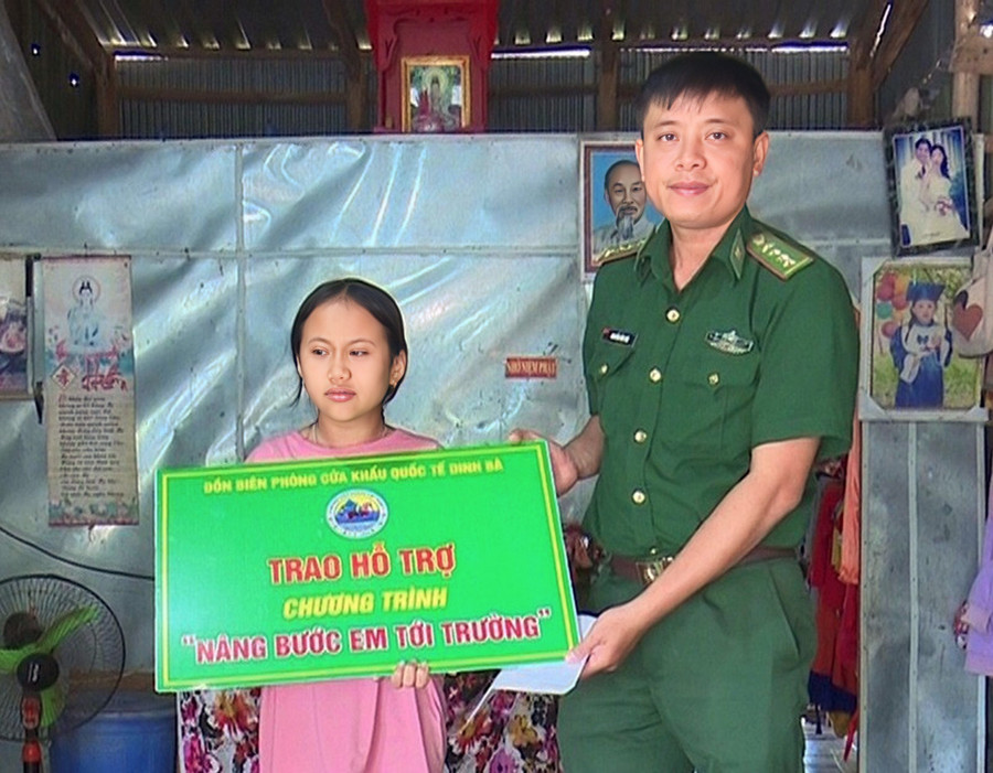 Chiến sĩ Đồn biên phòng cửa khẩu quốc tế Dinh Bà trao hỗ trợ từ Chương trình “Nâng bước em tới trường” cho học sinh có hoàn cảnh khó khăn tại xã Tân Hộ Cơ (huyện Tân Hồng)