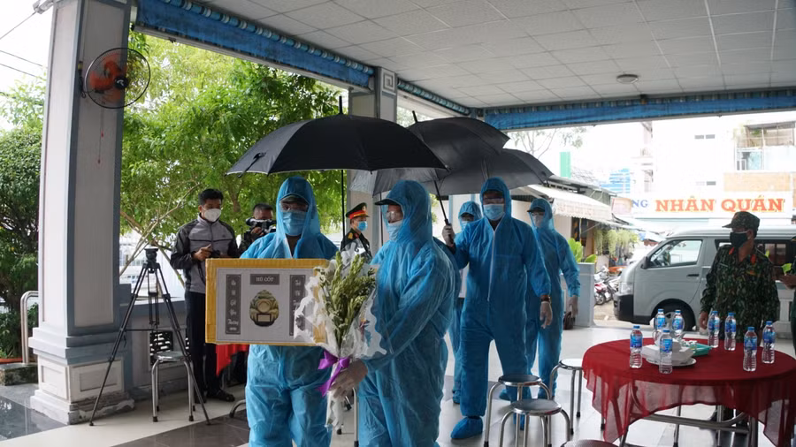 Cán bộ chiến sĩ Bộ chỉ huy quân sự TP. Cần Thơ hỗ trợ bàn giao tro cốt về với gia đình.