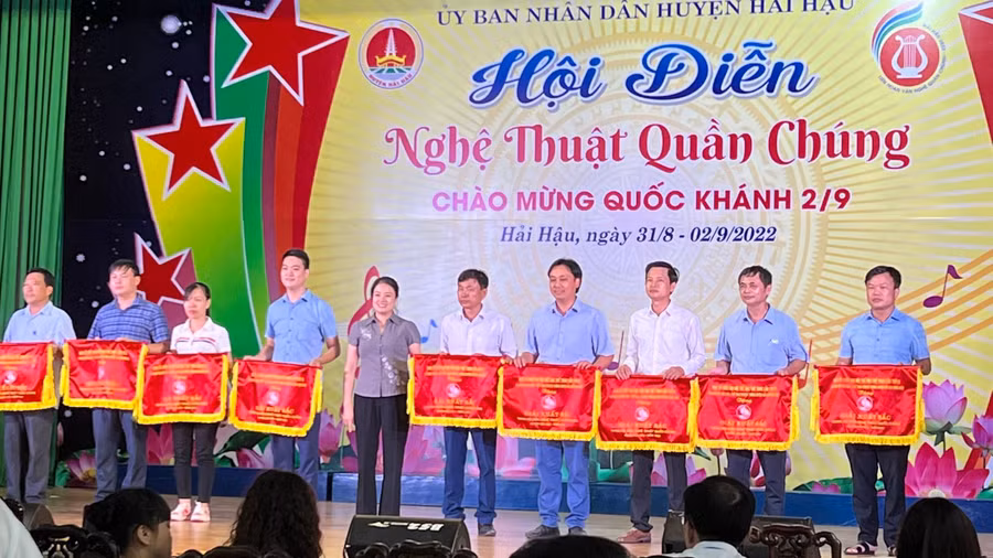 Ông Nguyễn Công Mẫn - Phó Chủ tịch UBND xã Hải Lý (bìa phải) và các đơn vị nhận cờ của UBND huyện Hải Hậu tiết mục văn nghệ xuất sắc.