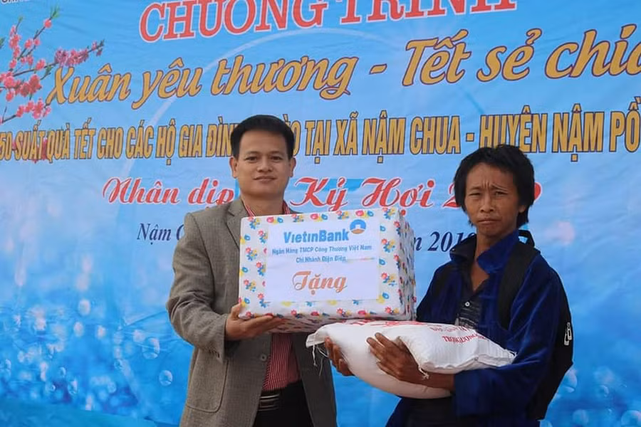 Ông Vũ Thanh Hải, Trưởng phòng NN&PTNT huyện Nậm Pồ (bên trái) trao quà cho hộ nghèo