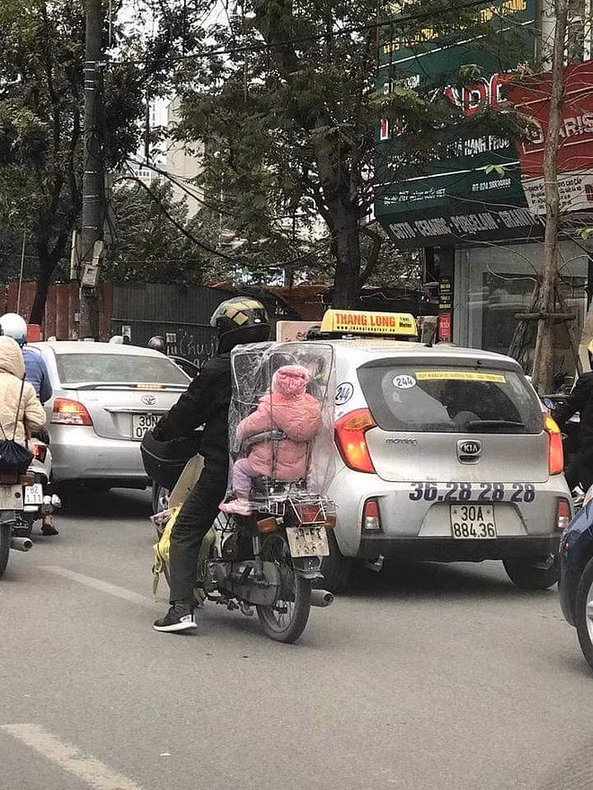 Hình ảnh cha chụp túi giữ ấm cho con trong ngày Hà Nội chuyển rét khiến nhiều người cay mắt - Hình 1