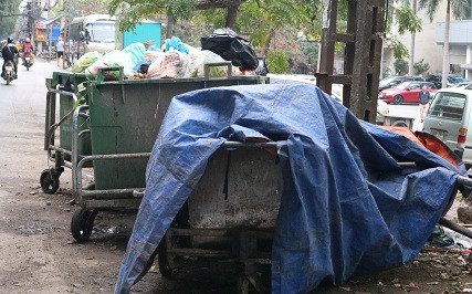 Trên tuyến phó Đê La Thành, rải rác nhiều xe chất đầy phế thải, phủ bạt kín mít. Phần lớn rác thải trên xe, đều là rác thải sinh hoạt. Người dân sinh sống tại tuyến phố này cho biết, những xe rác này đã được tập kết ở đây nhiều ngày nhưng chưa được chuyển đi.