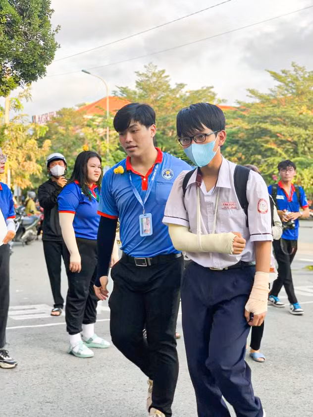 Hình ảnh những chiếc áo xanh tình nguyện hỗ trợ thí sinh bị thương đến phòng thi không còn xa lạ.