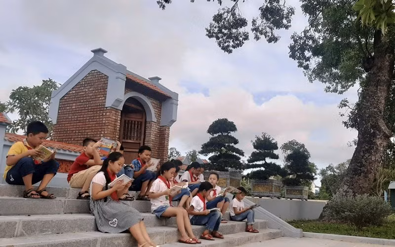 Học sinh trường Tiểu học thị trấn Tiên Điền (huyện Nghi Xuân) đọc truyện Kiều trong khuôn viên nhà trường.