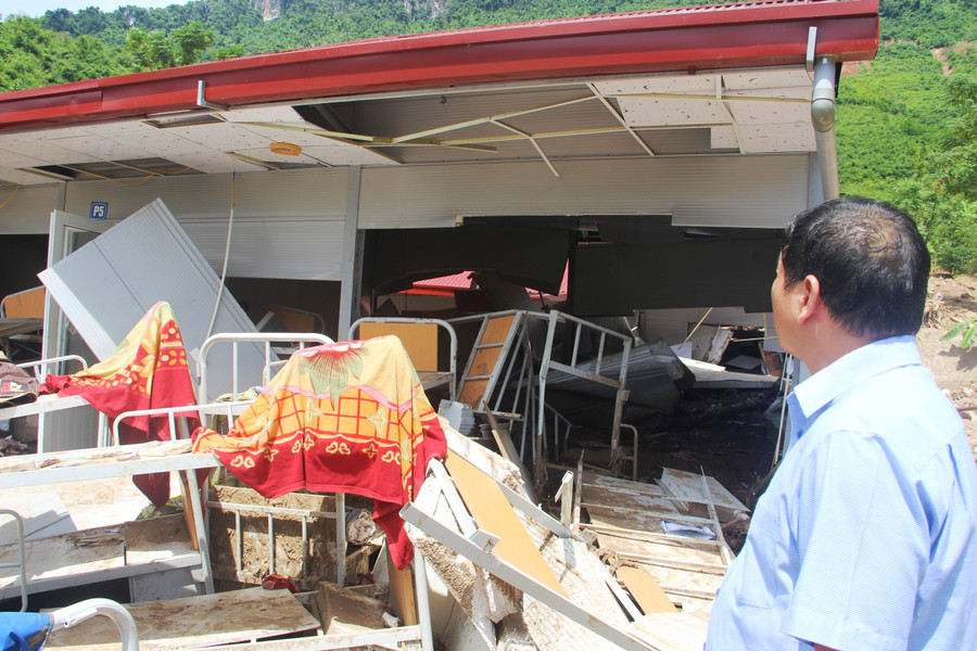 Thầy giáo Phạm Văn Kiên xót xa đứng nhìn đống đổ nát.