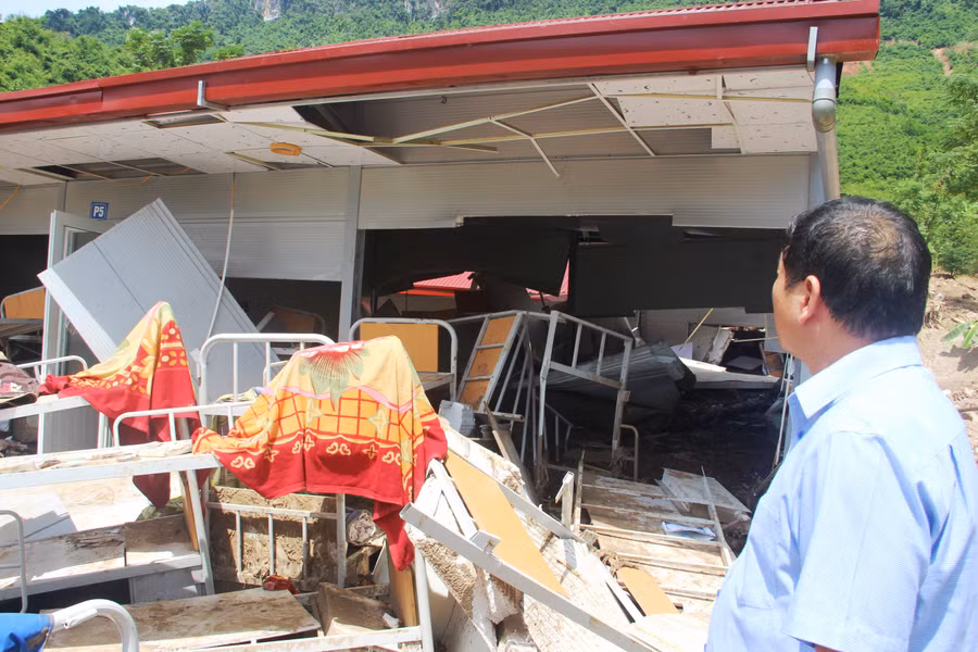 Thầy giáo Phạm Văn Kiên xót xa đứng nhìn đống đổ nát.