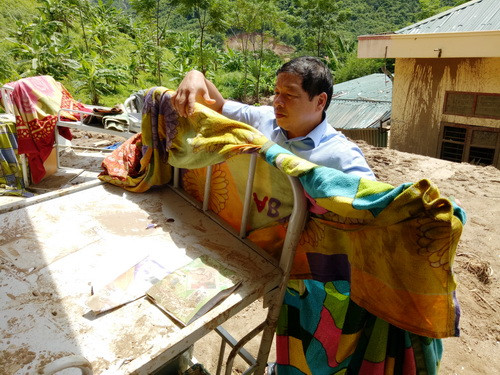 Thầy hiệu trưởng nhà trường nhặt nhạnh những chiếc chăn của học sinh đem ra phơi.