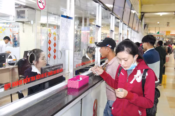 Hành kháchmua vé xetại bến xe Miền Đông - Ảnh: Phan Tư