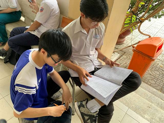 Nhiều bạn học sinh chọn những chỗ ngồi lý tưởng trong hành lang phòng thi để ôn bài