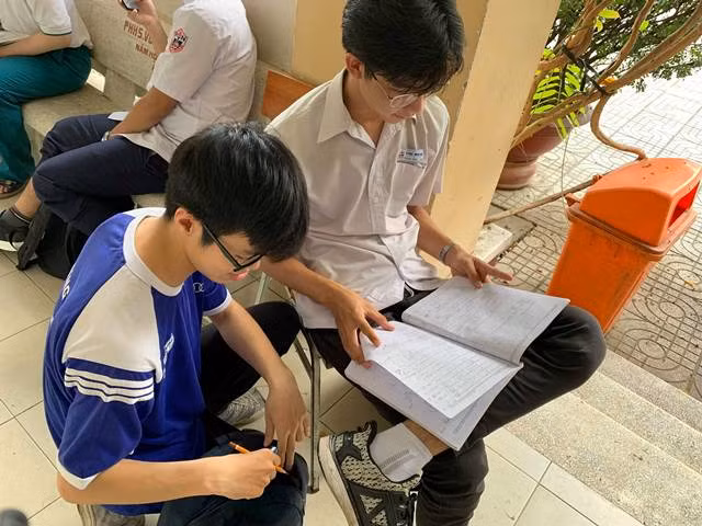 Nhiều bạn học sinh chọn những chỗ ngồi lý tưởng trong hành lang phòng thi để ôn bài