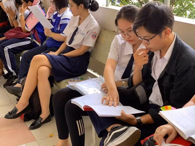 Thí sinh dự thi tại hội đồng thi THPT Phú Nhuận tranh thủ cùng nhau ôn lại bài trước giờ thi môn Toán