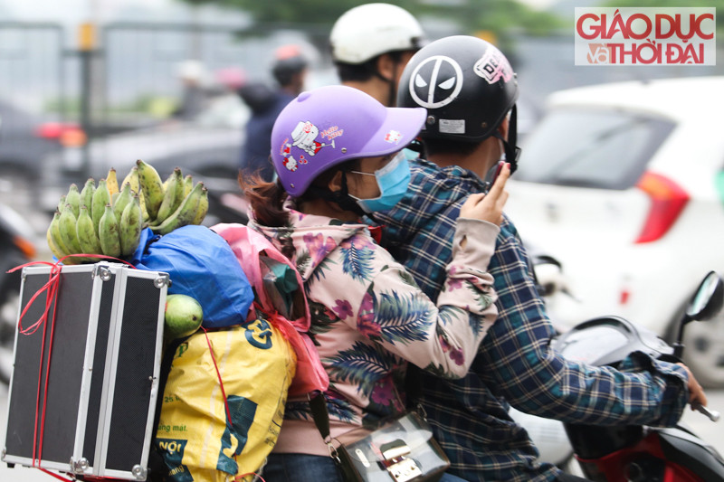 Hôm nay TP Hà Nội có mưa phùn, nhiều người chọn phương án lên Thủ đô bằng xe máy phải mặc áo mưa.