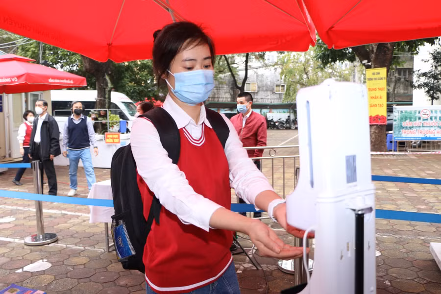 Học sinh vào trường đi theo lối phân luồng, đo thân nhiệt và sát khuẩn tay trước khi vào lớp.