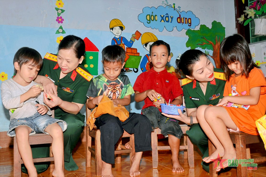 Phụ nữ Quân đội chia sẻ, động viên các cháu người dân tộc thiểu số học tập tại trường mầm non của Binh đoàn 15. Ảnh: Báo Quân đội nhân dân. Phụ nữ Quân đội chia sẻ, động viên các cháu người dân tộc thiểu số học tập tại trường mầm non của Binh đoàn 15. Ảnh: Báo Quân đội nhân dân.