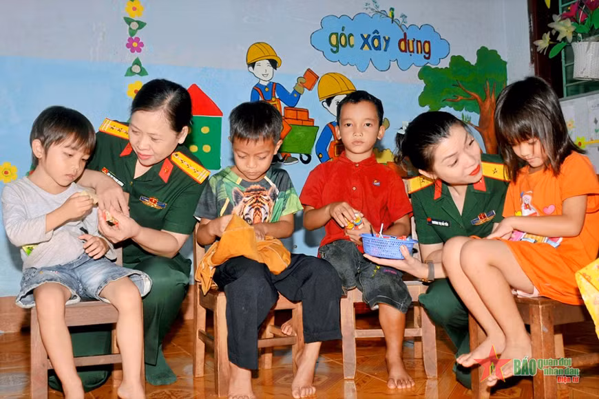 Phụ nữ Quân đội chia sẻ, động viên các cháu người dân tộc thiểu số học tập tại trường mầm non của Binh đoàn 15. Ảnh: Báo Quân đội nhân dân.