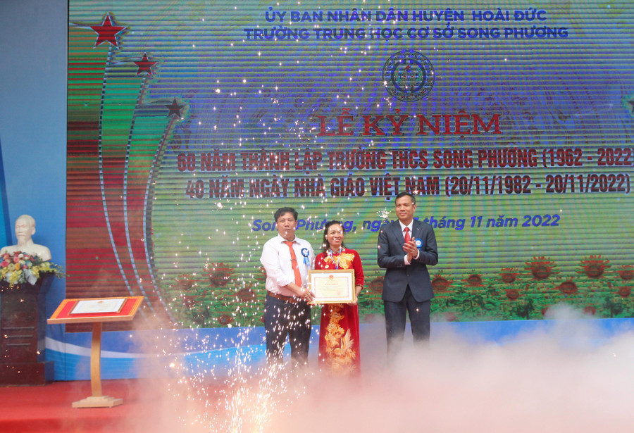Ông Nguyễn Trung Thuận - Phó Chủ tịch UBND huyện Hoài Đức (bìa phải) trao tặng đại diện Trường THCS Song Phương Bằng khen của Bộ trưởng Bộ GD&amp;ĐT nhân dịp kỷ niệm 60 năm thành lập trường.
