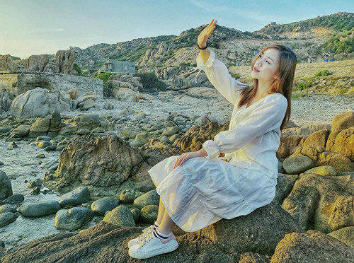 Quỳnh Kool mặc váy suông, kết hợp với giày thể thao đồng màu khi đi du lịch. Quỳnh Kool mặc váy suông, kết hợp với giày thể thao đồng màu khi đi du lịch.