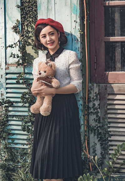 Diễn viên mặc theo phong cách cổ điển với sơ mi cổ Peter Pan, chân váy xếp ly và mũ beret. Diễn viên trẻ thanh lịch khi ăn mặc theo phong cách cổ điển với sơ mi cổ Peter Pan, chân váy xếp ly và mũ beret.