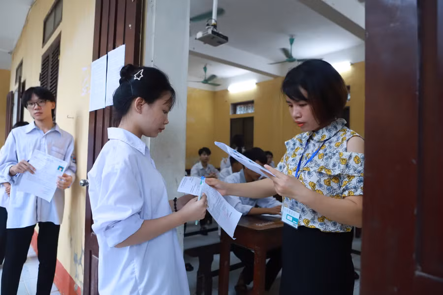 Cán bộ giám thị gọi thí sinh vào phòng thi tại Trường THPT Nam Trực. Ảnh: Đình Tuệ.