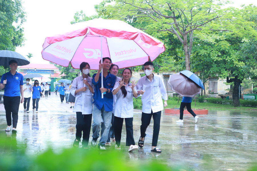 Các thí sinh được thanh niên tình nguyện hỗ trợ che mưa bằng ô cỡ lớn từ cổng vào sân trường. Ảnh: Đình Tuệ. Các thí sinh được thanh niên tình nguyện hỗ trợ che mưa bằng ô cỡ lớn từ cổng vào sân trường. Ảnh: Đình Tuệ.