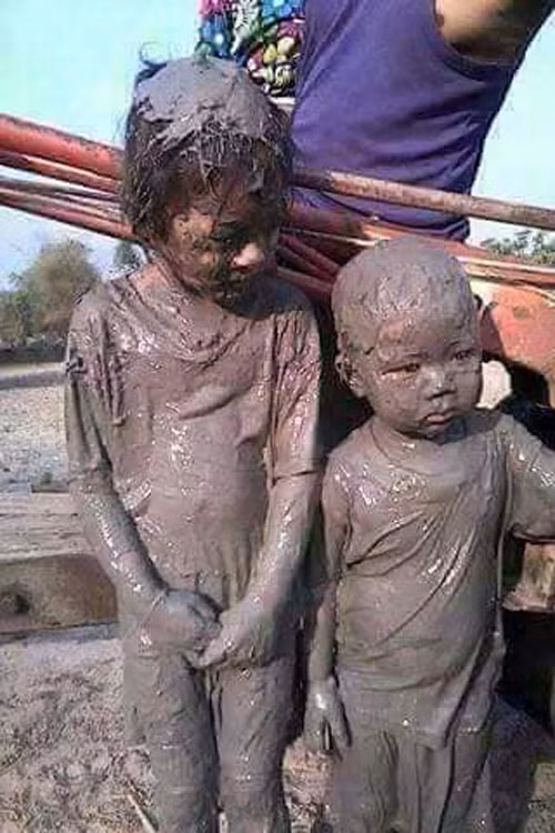 Hai bé lắm lem bùn đất.