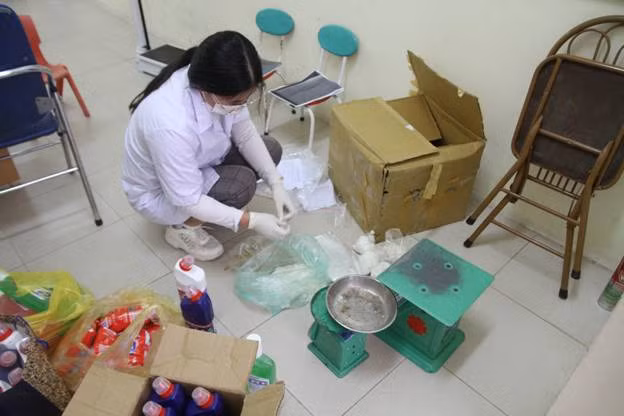 Nhân viên y tế của nhà trường đang chia từng gói Cloramin B để chuẩn bị cho phun khử trùng