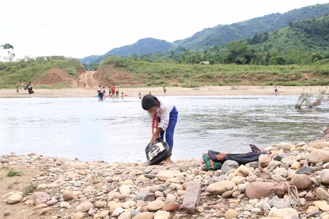 Ngày ngày các em học sinh phải lội qua sông để đến trường học chữ
