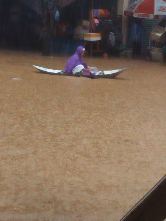 Nước lũ dâng cao, người dân lưu thông bằng thuyền.