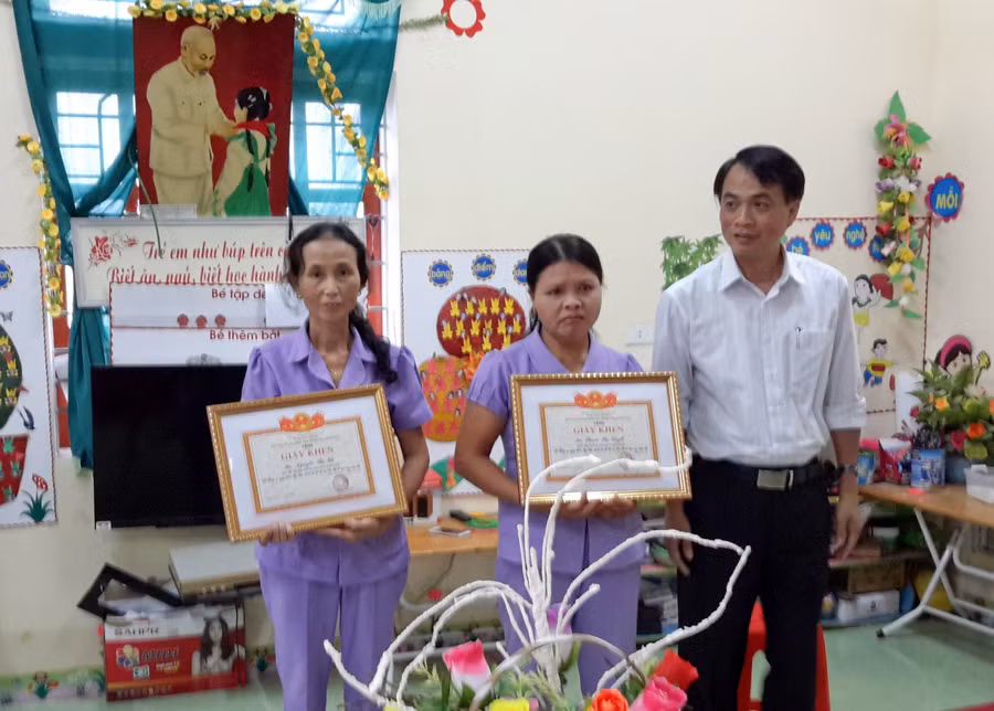 Ông Đặng Văn Hóa - Trưởng phòng GD-ĐT huyện Thanh Chương, Nghệ An - trao giấy khen và phần thưởng cho cô Tuyết và cô Hà chiều 19/4